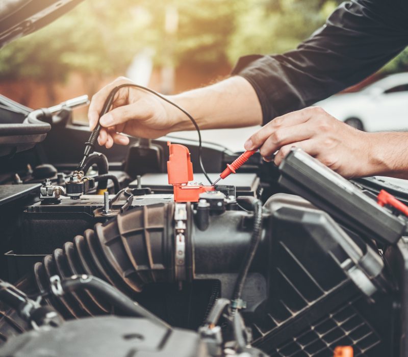 Auto mechanic working in garage Technician Hands of car mechanic working in auto repair Service and Maintenance car battery check.